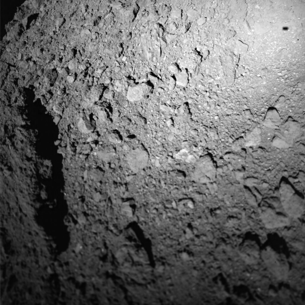 Фото поверхности астероида Рюгу MASCOT JAXA/U Tokyo/Kochi U/Rikkyo U/Nagoya U/ Chiba Inst Tech/Meiji U/U Aizu/AIST (links); MASCOT/DLR/JAXA (rechts).